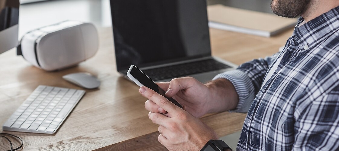 A man with mobile phone and computer