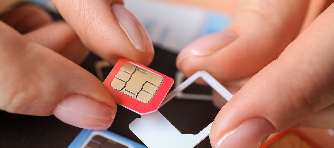 Hands of a person replacing a SIM card