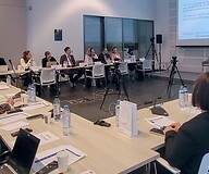 A group of people at tables in a conference room