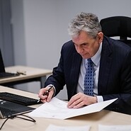Prezes Jacek Oko podpisujący dokumenty
