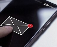 palce na smartfonie wskazuje ikonę koperty