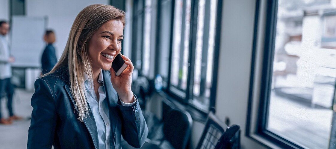 Kobieta w stroju biznesowym z telefonem komórkowym