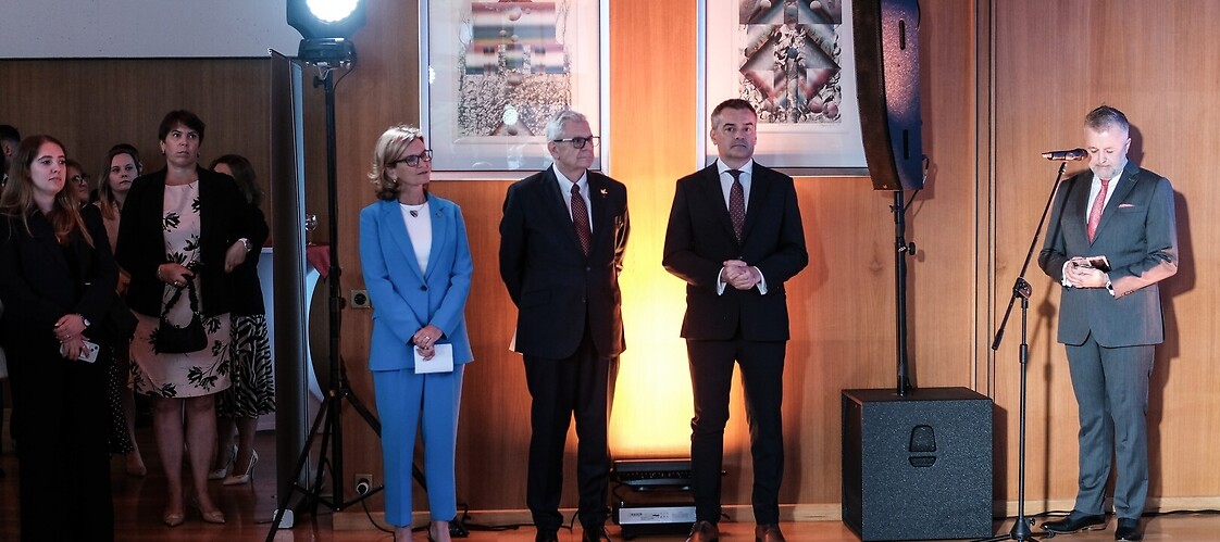 Cztery osoby stoją w sali konferencyjnej