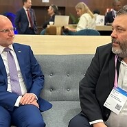 Dwóch mezczyzn siedzi na kanapie w przestrzeni konferencyjnej