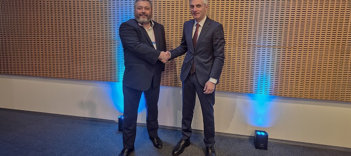 Dwaj mężczyźni w garniturach w przestrzeni konferencyjnej