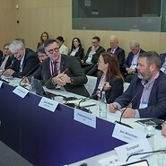 Grupa osób w garniturach za stołem konferencyjnym