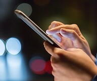 Dłoń osoby wybierającej numer na smartfonie