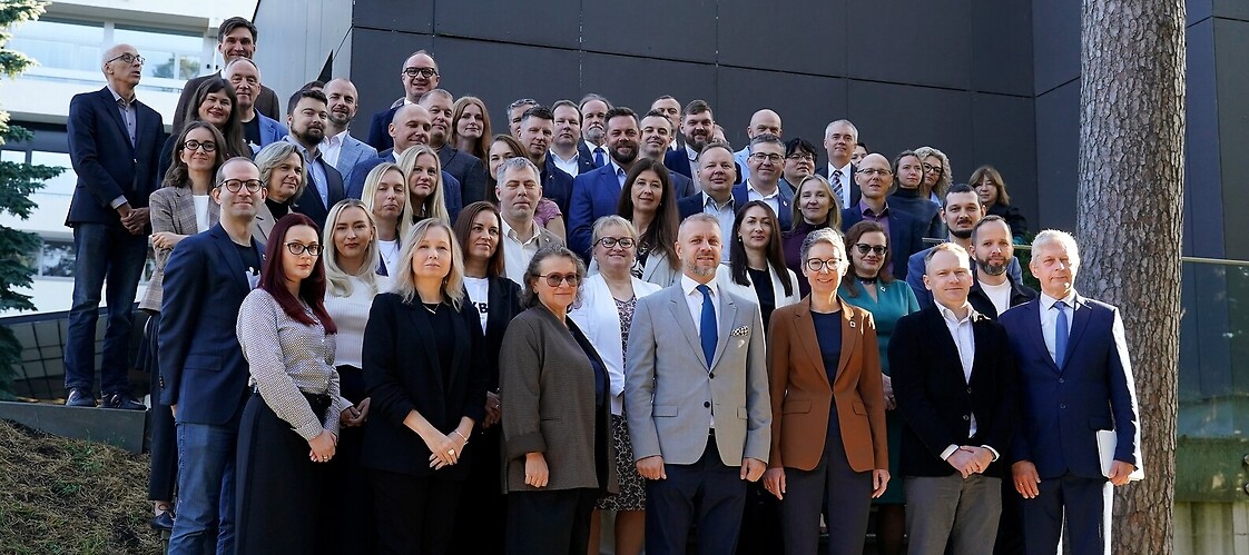 Grupa osób w strojach biznesowych pozuje zdjecia