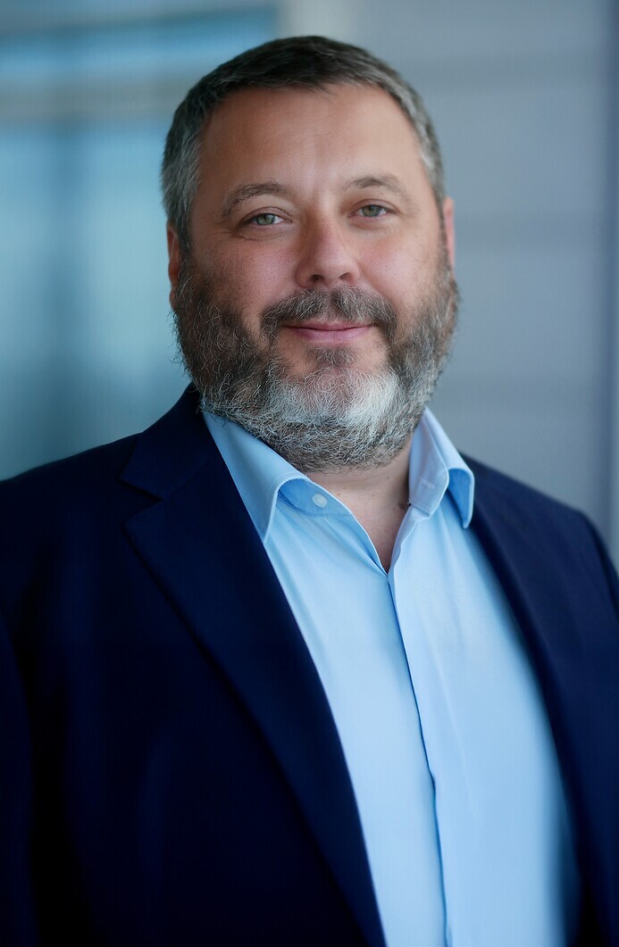 Prezes Przemysław Kuna w ciemnym garniturze i błękitnej koszuli